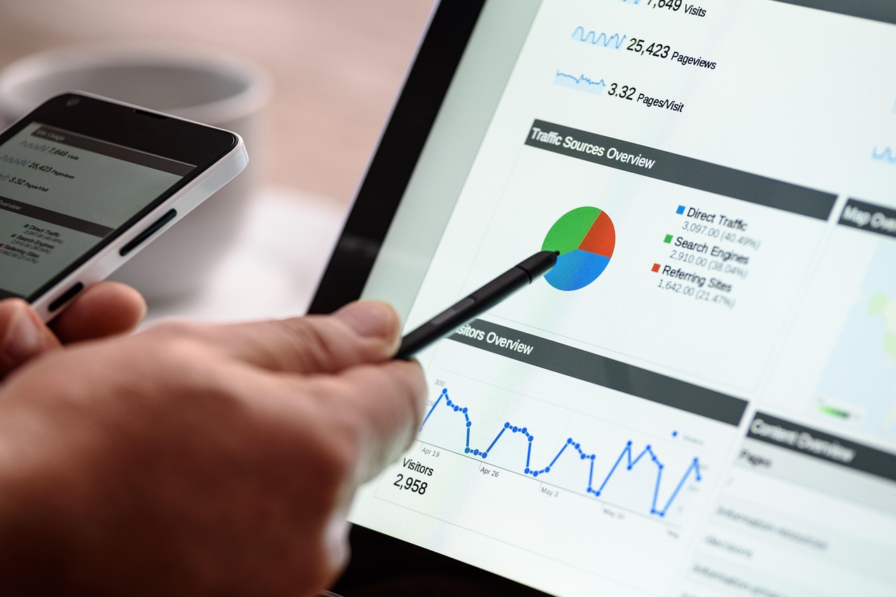 person analyzing website traffic data and performance charts on a tablet, illustrating SEO analysis and the impact of outdated content on search rankings.