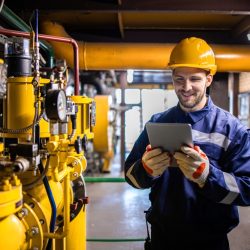 Professional industry worker checking production results of natural gas in refinery plant.